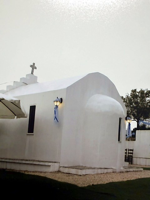 Το λευκό εκκλησάκι του Villa Domenica με τον τρούλο και τον σταυρό